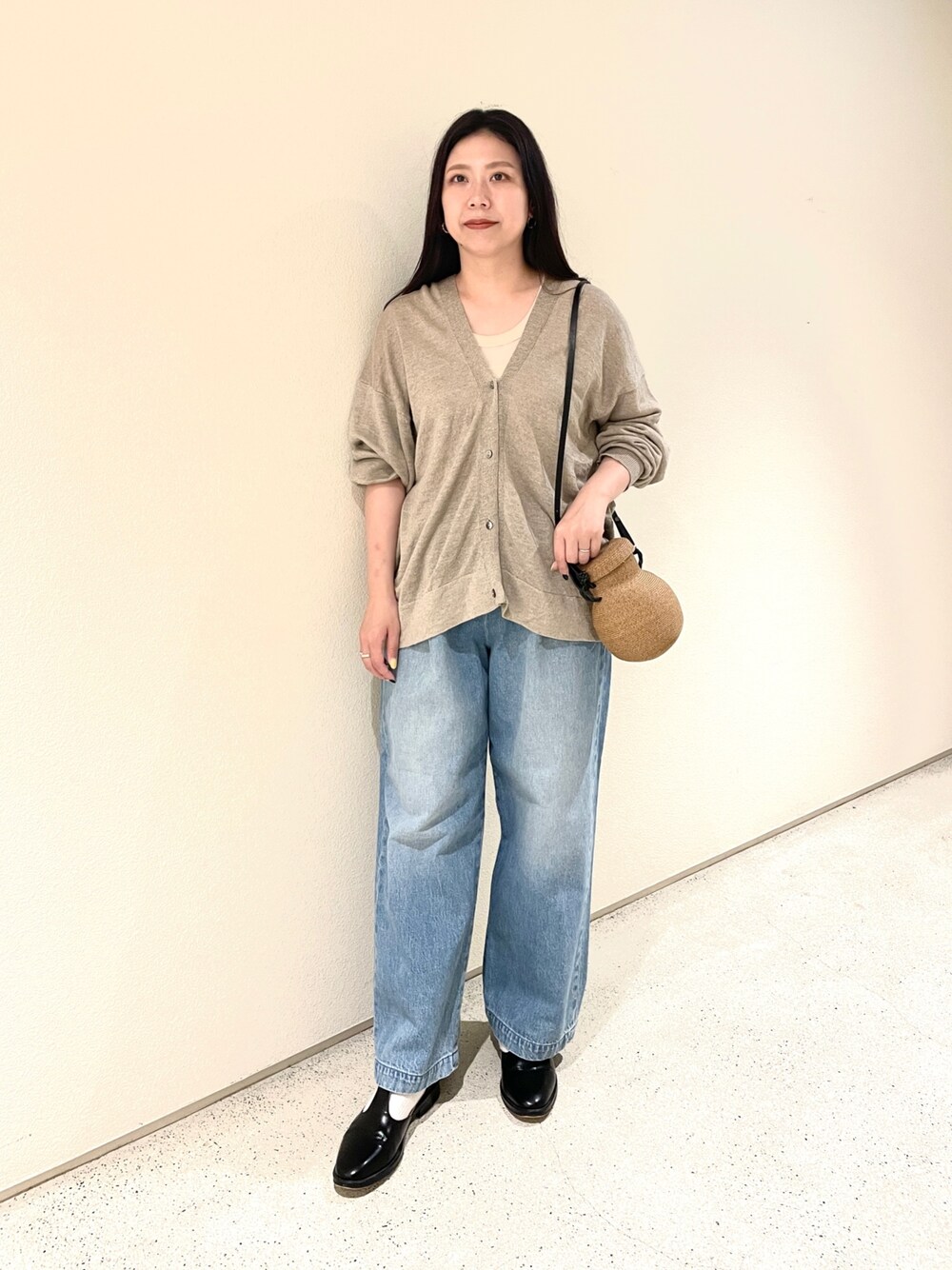 ベージュ系のカーディガン/ボレロ、ブルー系のデニムパンツ、ベージュ系のショルダーバッグを着用したレディースの夏コーディネートの1枚目の写真