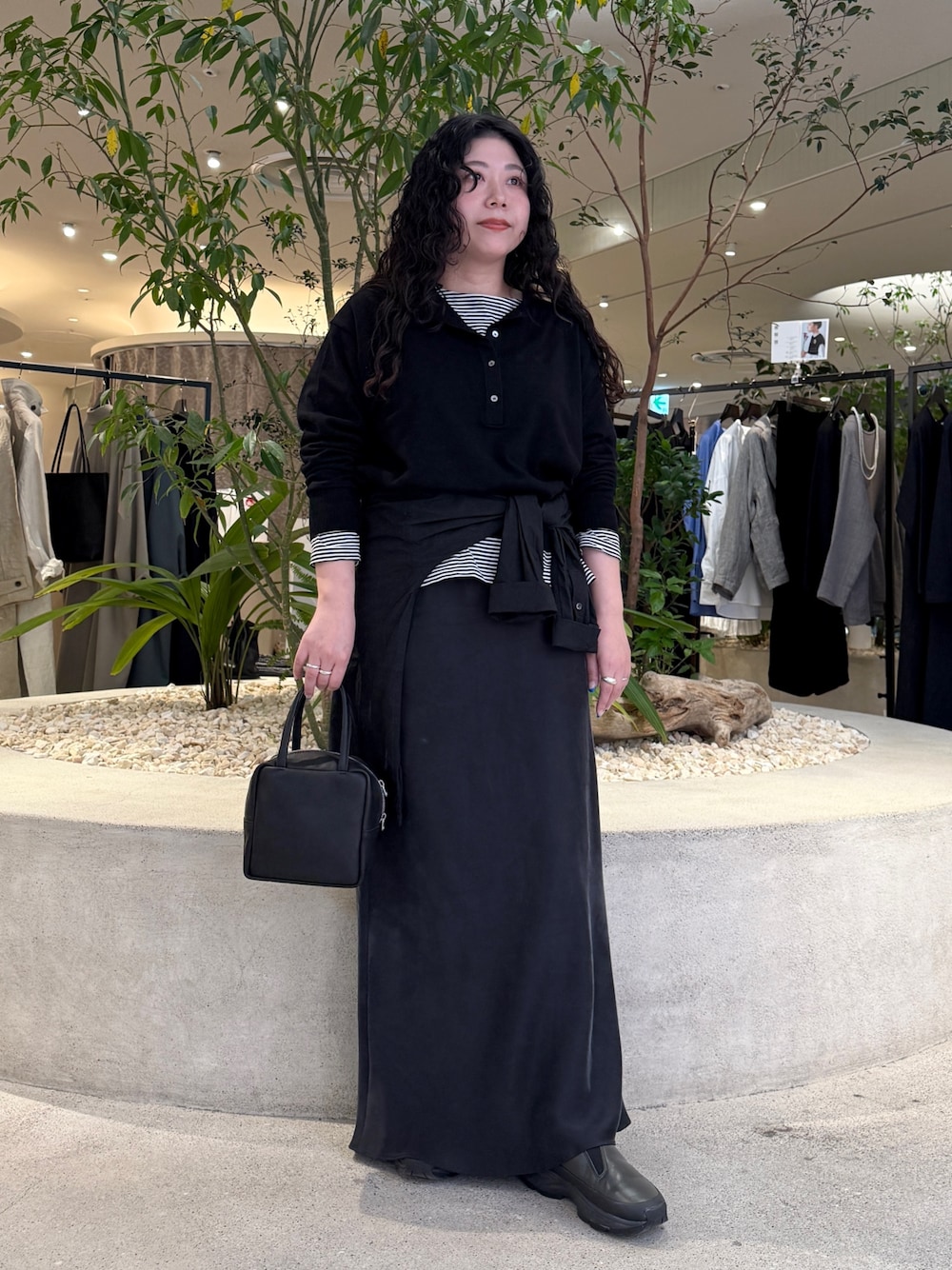 ブラック系のニット/セーター、ブラック系のTシャツ/カットソー、ブラック系のスカートを着用したレディースの冬コーディネートの1枚目の写真