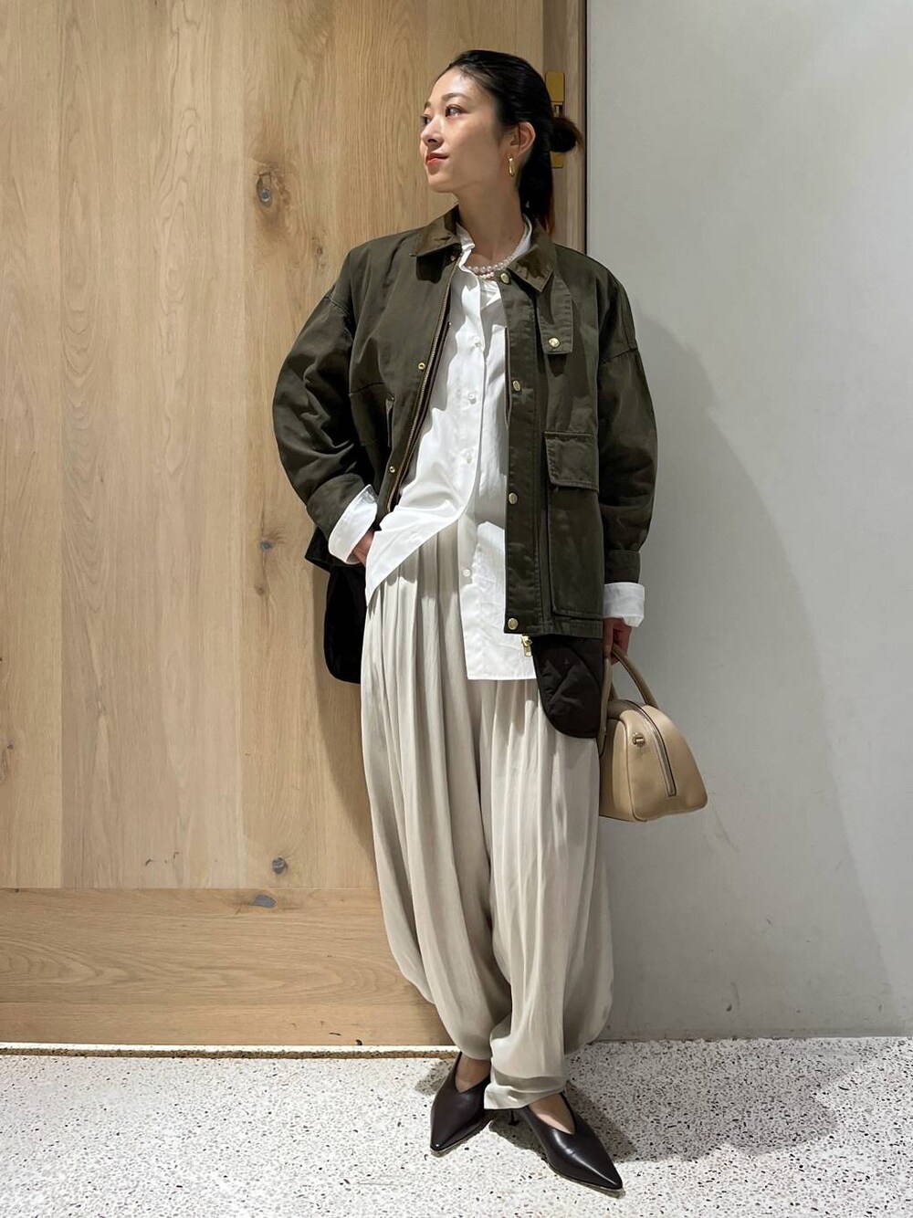 ホワイト系のシャツ/ブラウス、グリーン系のブルゾン、ホワイト系のその他パンツを着用したレディースの秋コーディネートの1枚目の写真
