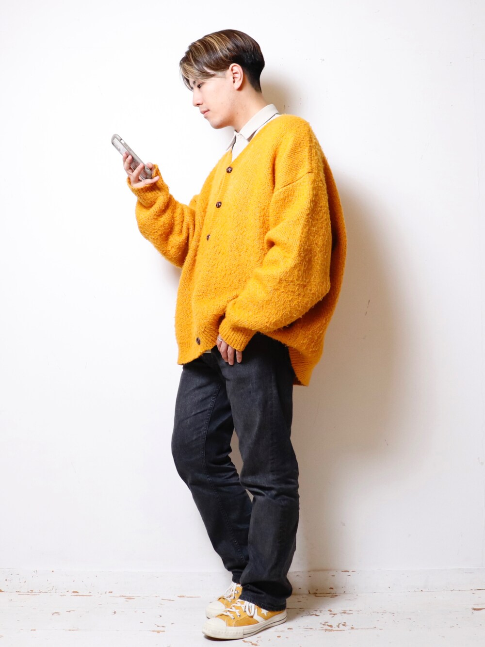 イエロー系のカーディガン/ボレロ、ブラック系のデニムパンツ、イエロー系のスニーカーを着用したメンズの秋コーディネートの1枚目の写真
