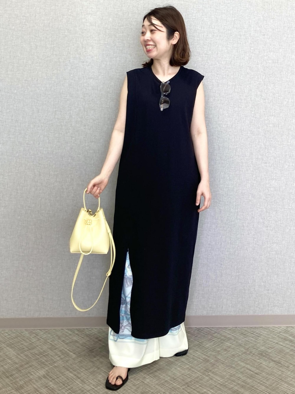 ベージュ系のハンドバッグ、ホワイト系のその他パンツ、ブラック系のサンダルを着用したレディースの春コーディネートの1枚目の写真