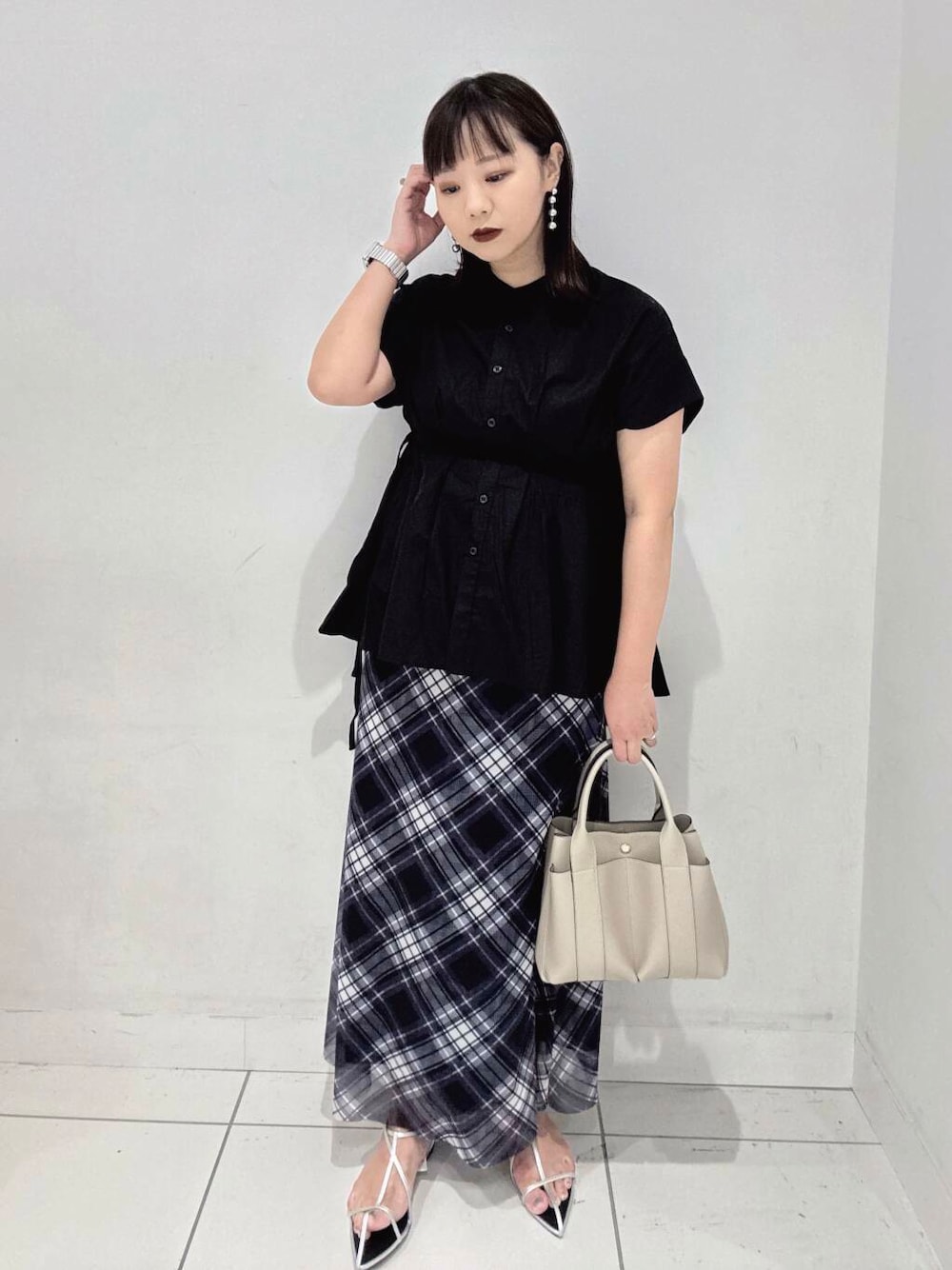 ホワイト系のトートバッグ、シルバー系のサンダル、ブラック系のシャツ/ブラウスを着用したレディースの夏コーディネートの1枚目の写真