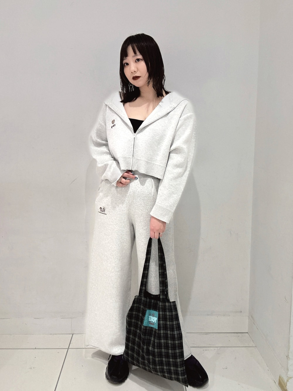 グレー系のパーカー、グレー系のスウェットパンツ、ブルー系のトートバッグを着用したレディースの秋コーディネートの1枚目の写真