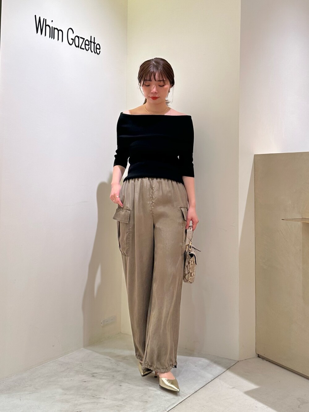 ブラック系のニット/セーター、ゴールド系のパンプス、ゴールド系のチョーカーを着用したレディースの春コーディネートの1枚目の写真