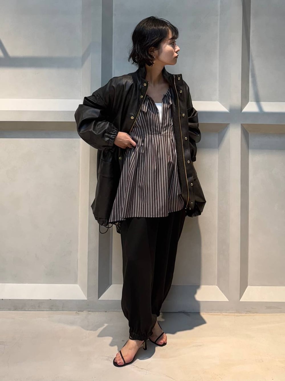 ホワイト系のキャミソール、ブラウン系のブルゾン、ブラウン系のその他パンツを着用したレディースの秋コーディネートの1枚目の写真