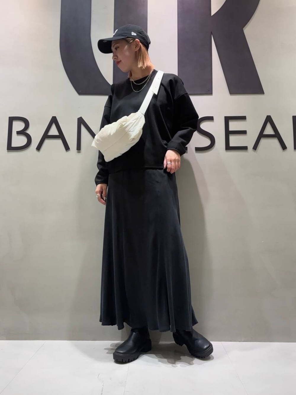 ブラック系のブーツ、ブラック系のTシャツ/カットソー、ブラック系のスカートを着用したレディースの冬コーディネートの1枚目の写真