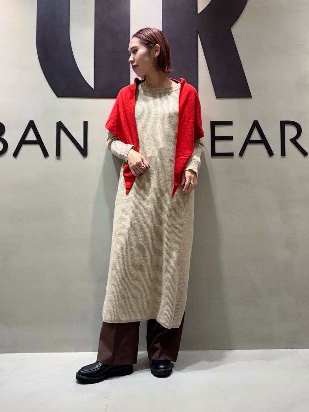 ブラウン系のその他パンツ、ベージュ系のワンピース、レッド系のストール/ショールを着用したレディースの冬コーディネートの1枚目の写真