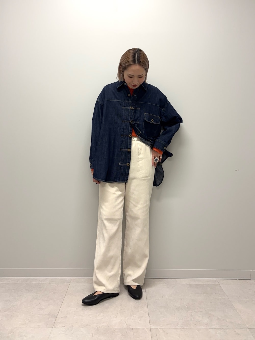 オレンジ系のニット/セーター、ブルー系のシャツ/ブラウス、ホワイト系のその他パンツを着用したレディースの冬コーディネートの1枚目の写真