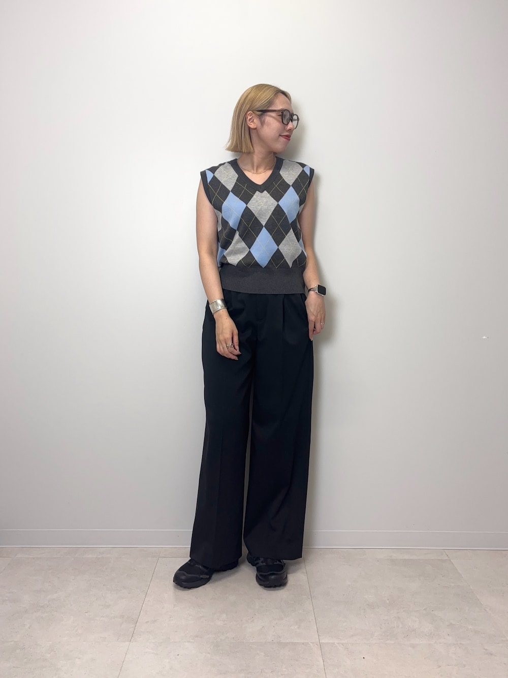 グレー系のベスト、ブラック系のその他パンツ、ブラック系のスニーカーを着用したレディースの夏コーディネートの1枚目の写真
