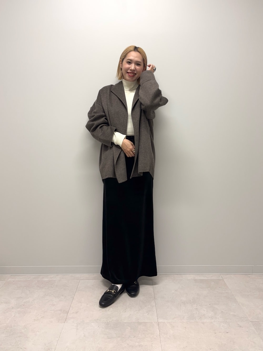 ブラウン系のその他アウター、ホワイト系のニット/セーター、ブラック系のスカートを着用したレディースの秋コーディネートの1枚目の写真