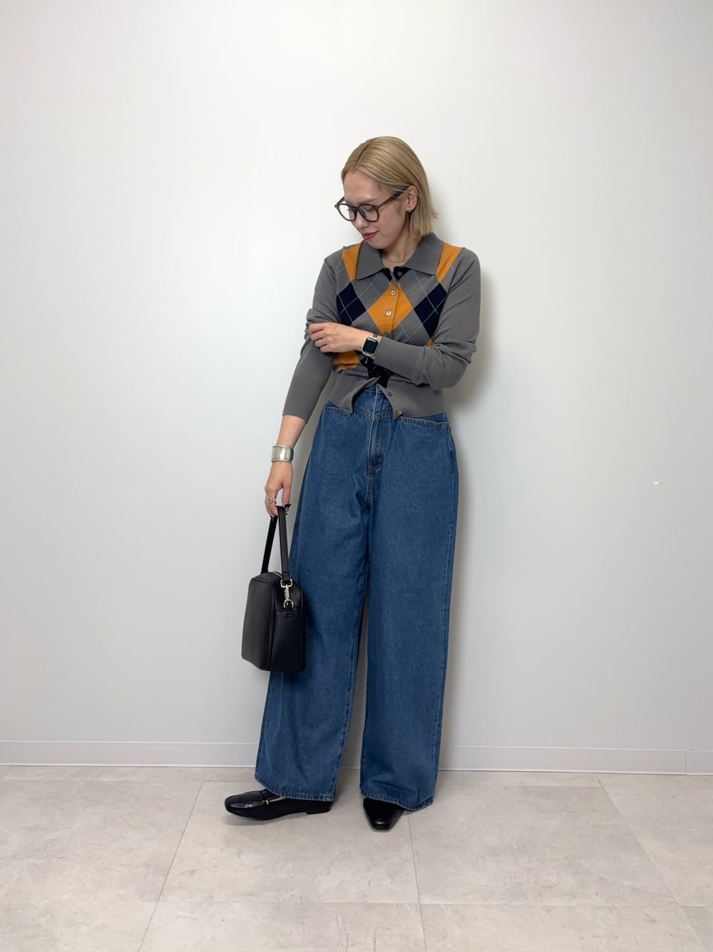 グレー系のカーディガン/ボレロ、ブルー系のデニムパンツ、ブラック系のショルダーバッグを着用したレディースの秋コーディネートの1枚目の写真