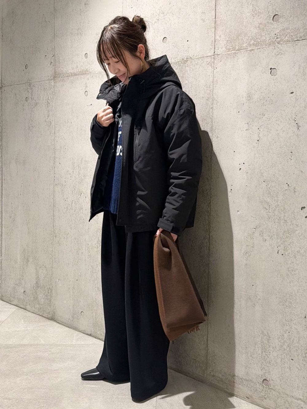 ブラック系のダウンジャケット/コート、ブルー系のニット/セーター、ブラック系のその他パンツを着用したレディースの秋コーディネートの1枚目の写真