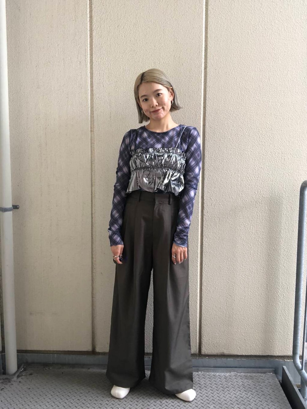 ホワイト系のブーツ、グリーン系のスラックス、シルバー系のベストを着用したレディースの夏コーディネートの1枚目の写真