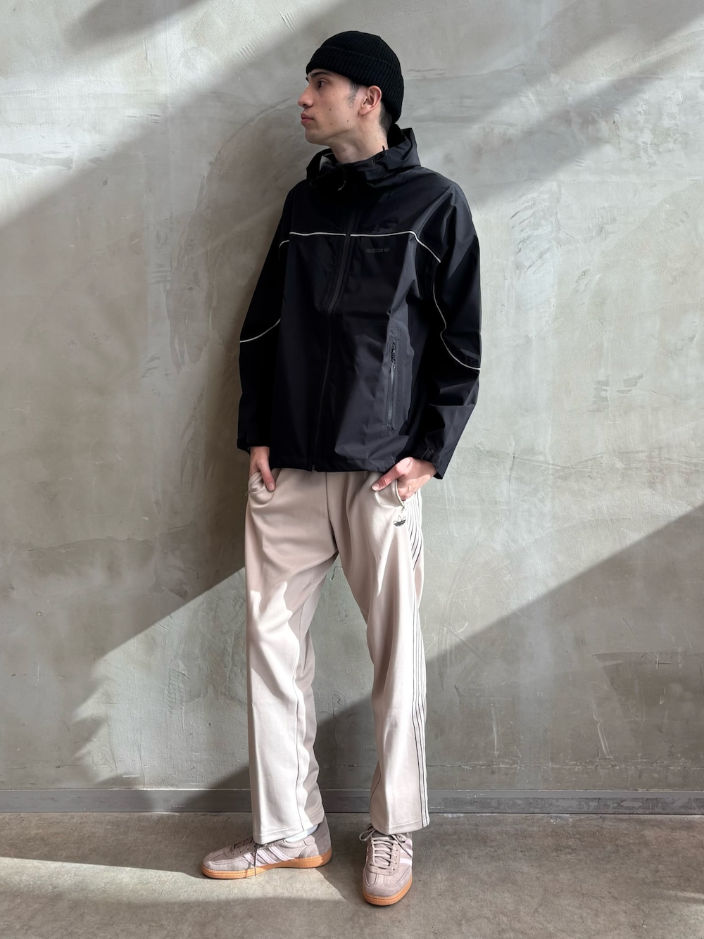 ブラック系のマウンテンパーカー、ベージュ系のその他パンツ、ブラウン系のスニーカーを着用したメンズの冬コーディネートの1枚目の写真