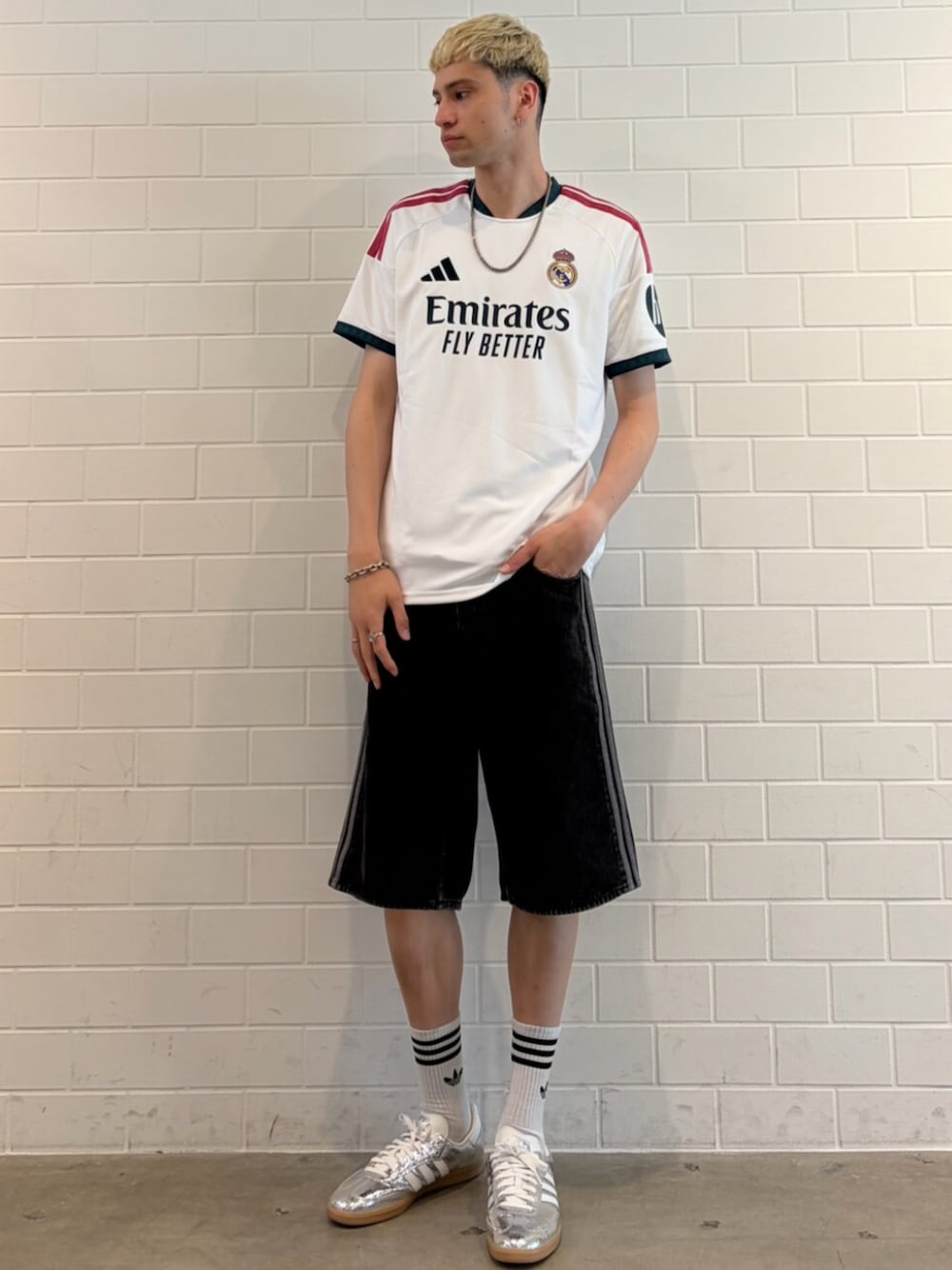 シルバー系のスニーカー、ブラック系のデニムパンツ、ホワイト系のTシャツ/カットソーを着用したメンズの夏コーディネートの1枚目の写真