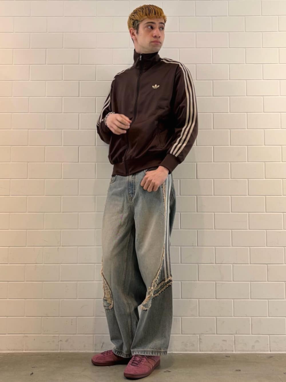 ブルー系のデニムパンツ、ブラウン系のジャージ、レッド系のシューズを着用したメンズの春コーディネートの1枚目の写真