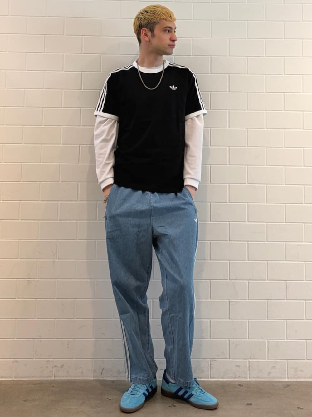 ブラック系のTシャツ/カットソー、ブルー系のシューズ、ブルー系のデニムパンツを着用したメンズの春コーディネートの1枚目の写真