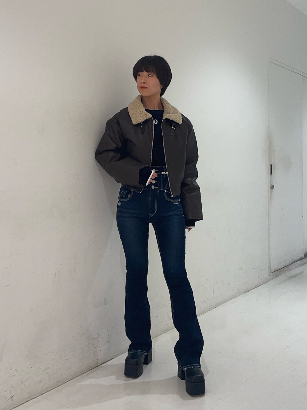 ブラック系のTシャツ/カットソー、ブラウン系のブルゾン、ブルー系のデニムパンツを着用したレディースの秋コーディネートの1枚目の写真