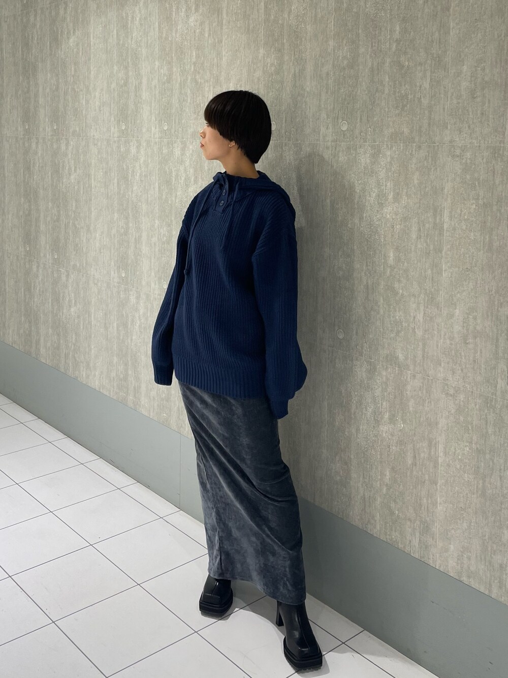 ブルー系のニット/セーター、ブラック系のブーツ、グレー系のスカートを着用したレディースの秋コーディネートの1枚目の写真