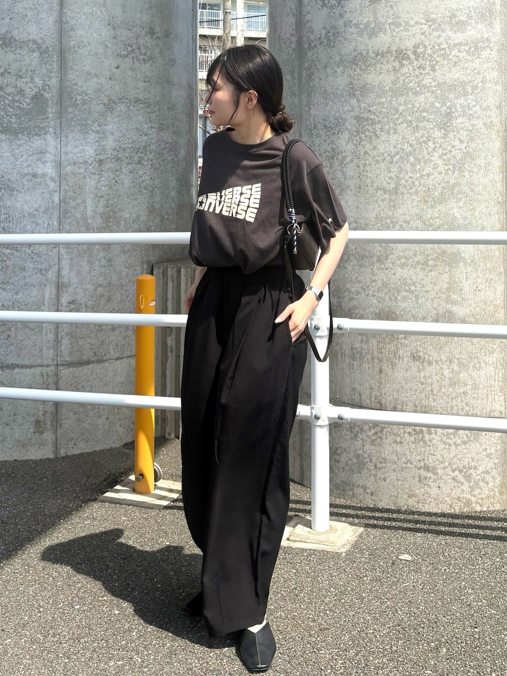 グレー系のTシャツ/カットソー、ブラック系のスラックス、グレー系のショルダーバッグを着用したレディースの春コーディネートの1枚目の写真