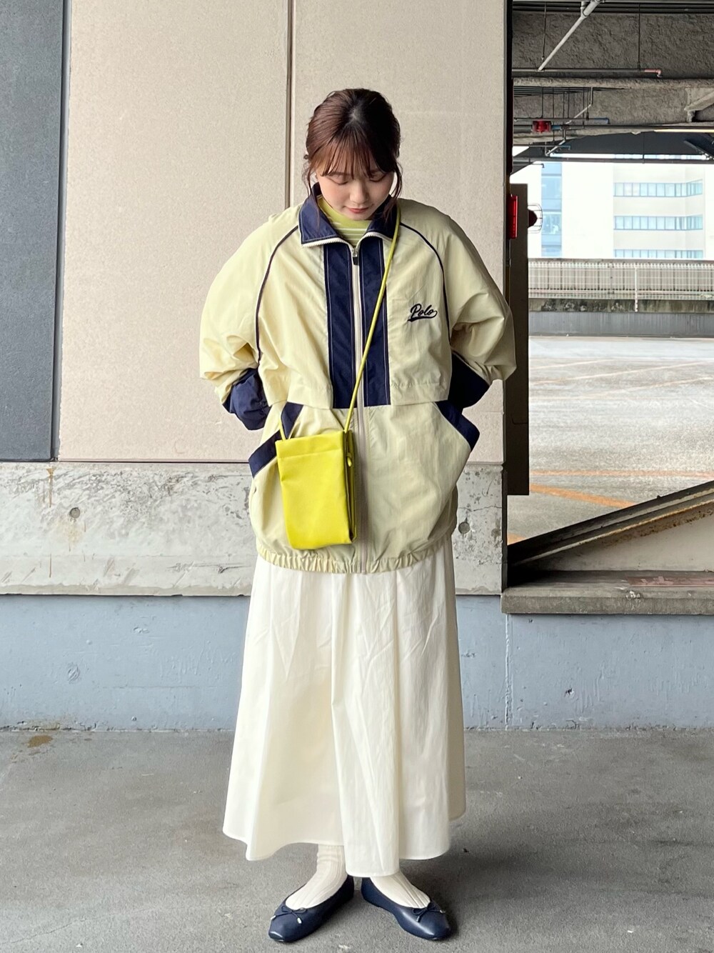 ベージュ系のナイロンジャケット、グリーン系のTシャツ/カットソー、グリーン系のショルダーバッグを着用したレディースの冬コーディネートの1枚目の写真