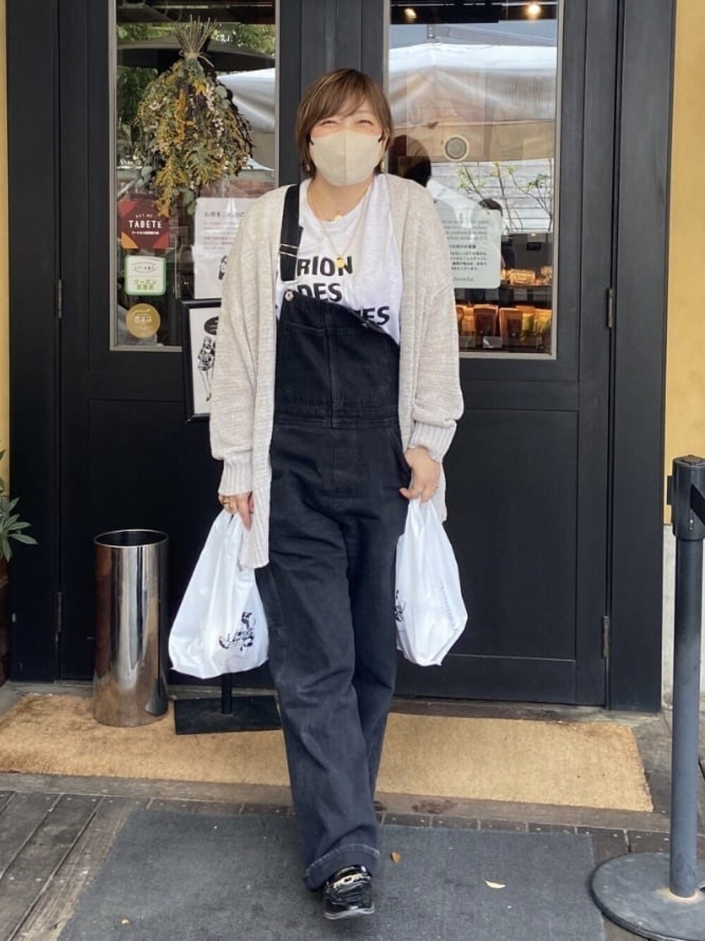 グレー系のカーディガン/ボレロ、ブラック系のサロペット/オーバーオールを着用したレディースの春コーディネートの1枚目の写真