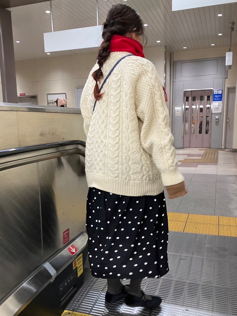 ホワイト系のカーディガン/ボレロ、ブラック系のワンピース/ドレス、レッド系のマフラーを着用したレディースの冬コーディネートの1枚目の写真