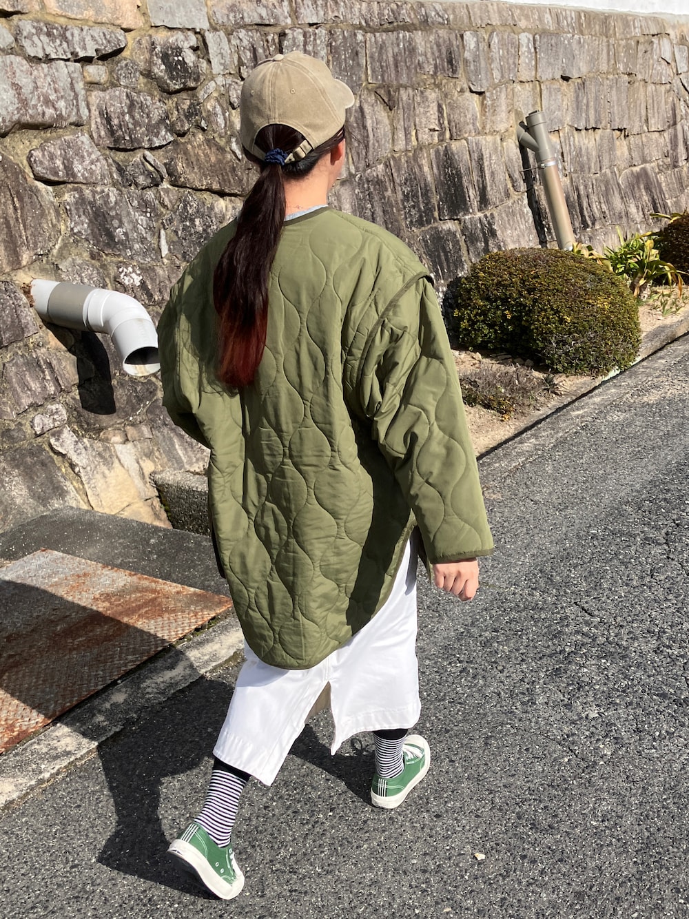 グリーン系のノーカラージャケット、グレー系のパーカー、ホワイト系のスカートを着用したレディースの冬コーディネートの1枚目の写真