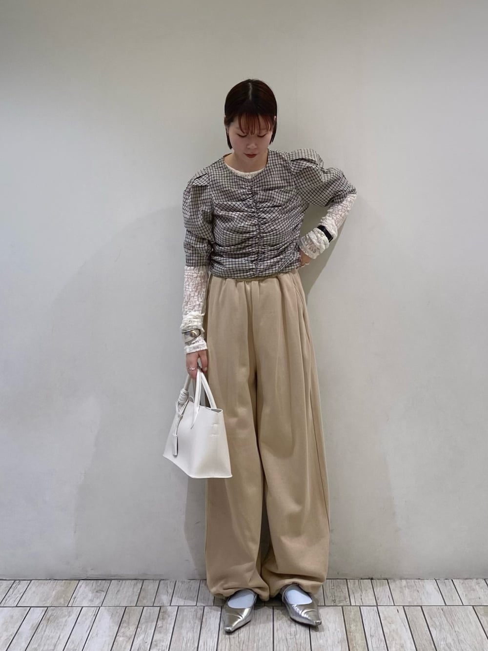 ベージュ系のシャツ/ブラウス、ベージュ系のその他パンツ、ホワイト系のハンドバッグを着用したレディースの春コーディネートの1枚目の写真