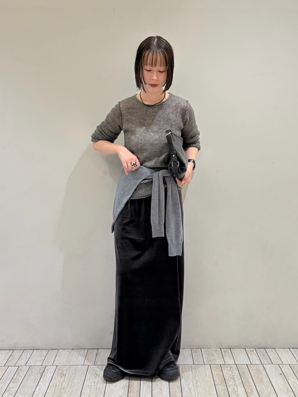 グレー系のニット/セーター、グレー系のカーディガン/ボレロ、グレー系のスカートを着用したレディースの秋コーディネートの1枚目の写真