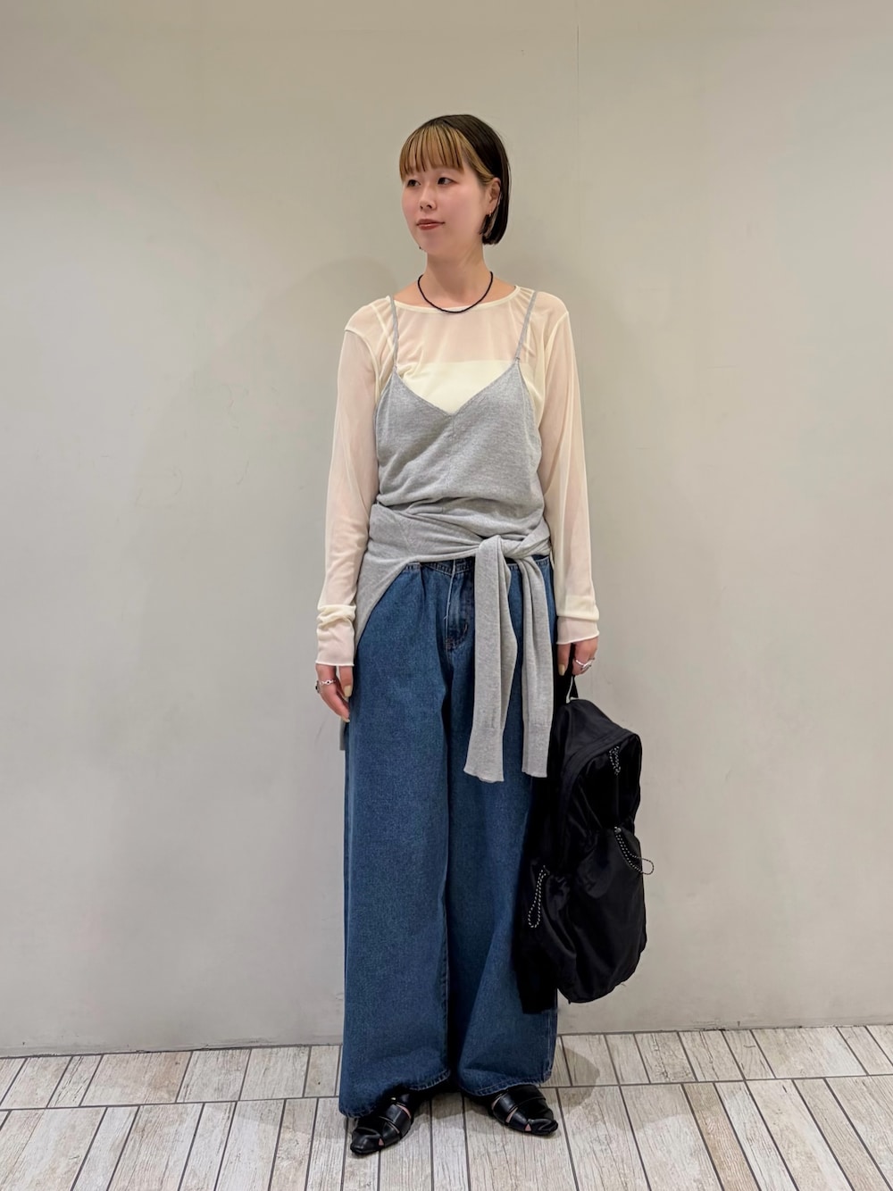 グレー系のカーディガン/ボレロ、ホワイト系のTシャツ/カットソー、ブルー系のデニムパンツを着用したレディースの秋コーディネートの1枚目の写真