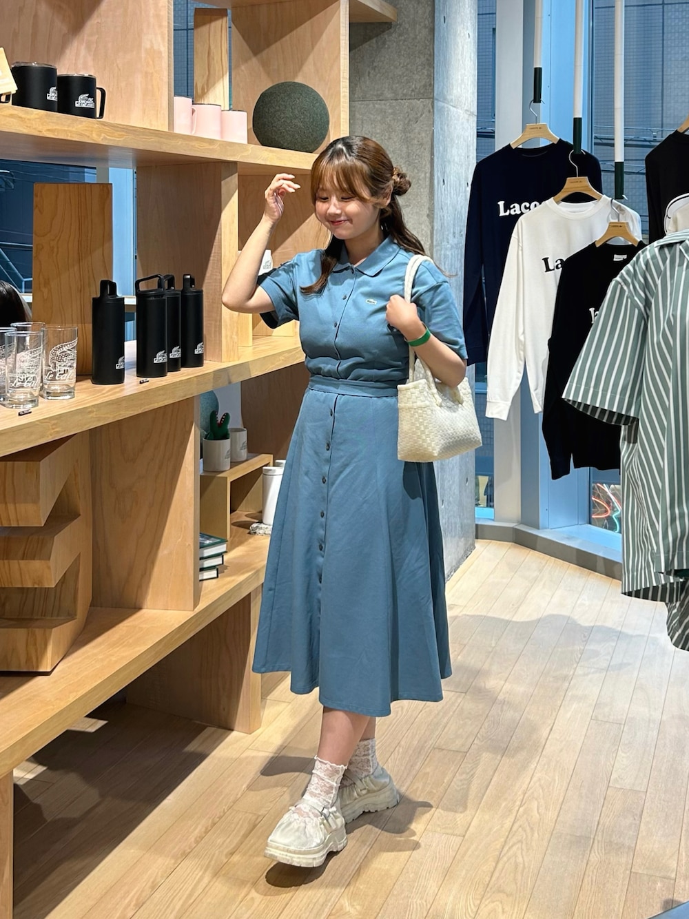 ブルー系のシャツワンピース、ブラック系のバレエシューズ、ホワイト系のかごバッグを着用したレディースの夏コーディネートの1枚目の写真