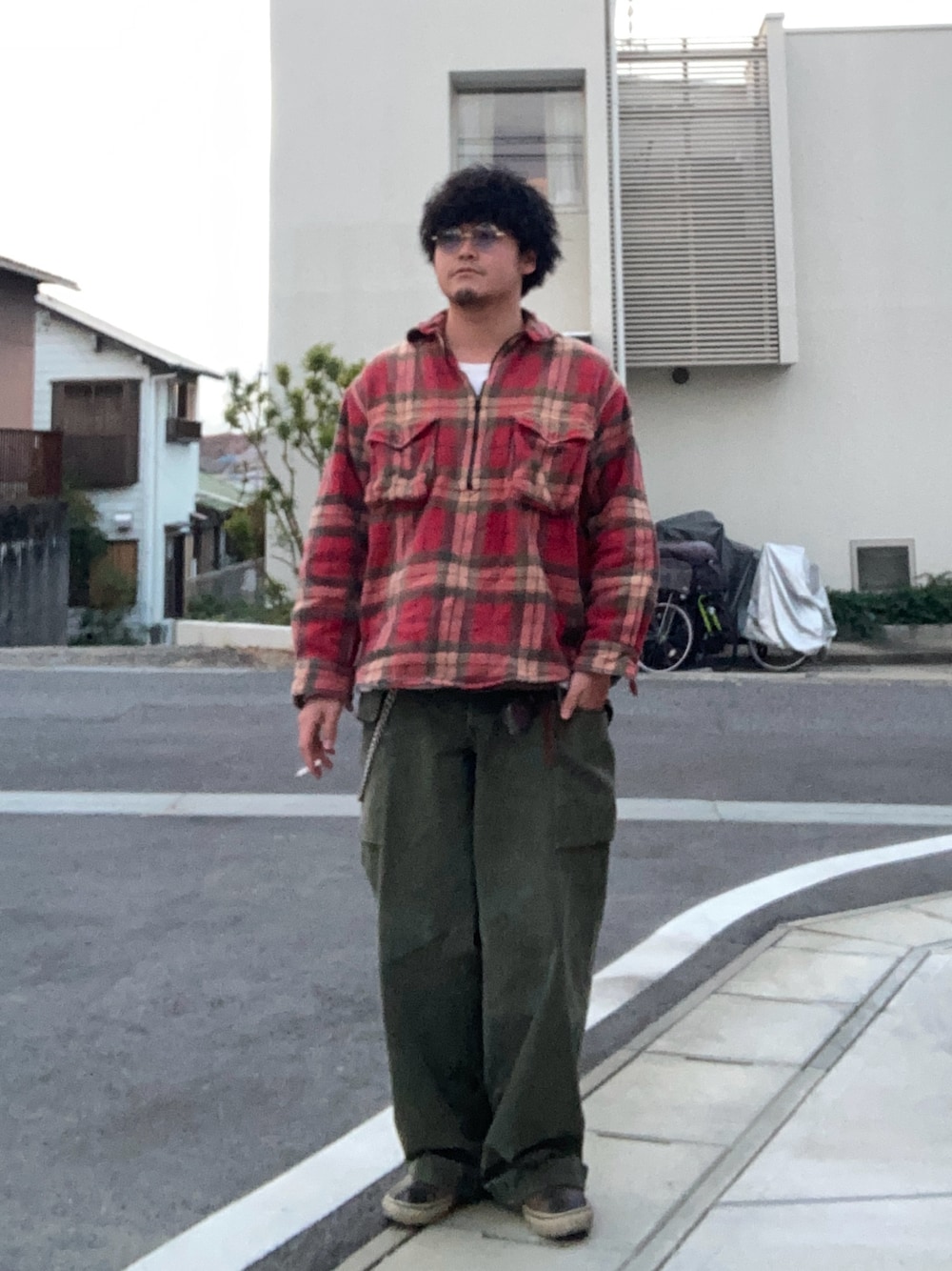グリーン系のカーゴパンツ、ベージュ系のスリッポン、レッド系のシャツ/ブラウスを着用したメンズの冬コーディネートの1枚目の写真