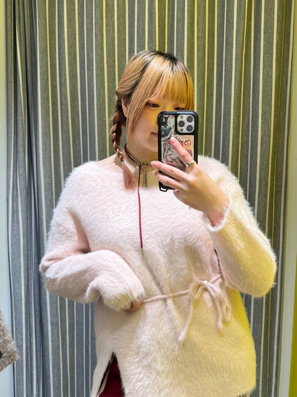 ピンク系のチュニック、レッド系のネックレスを着用したレディースの冬コーディネートの1枚目の写真