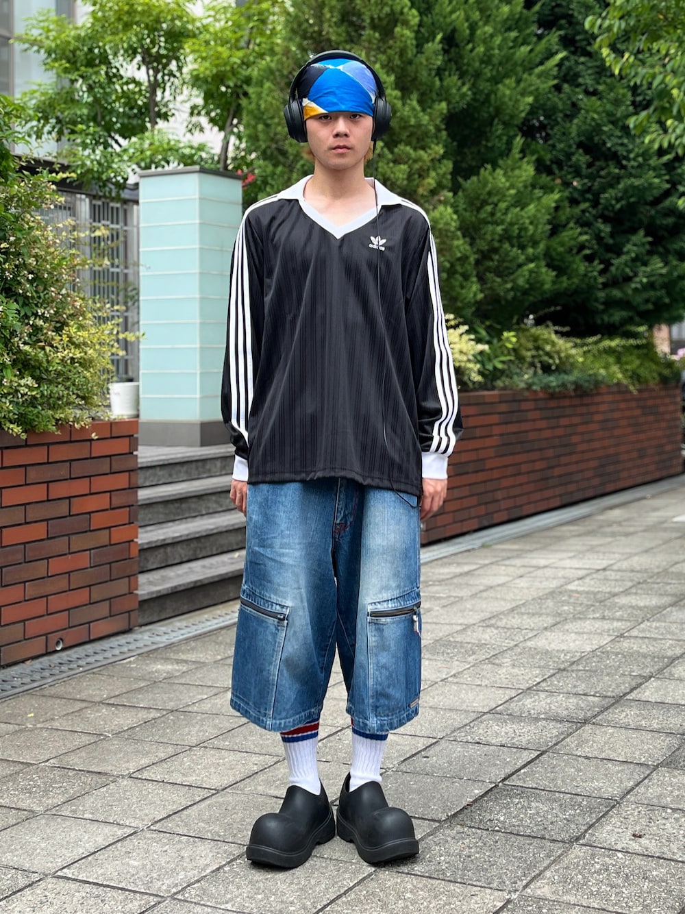 ブラック系のTシャツ/カットソー、ブルー系のデニムパンツ、ブラック系のスリッポンを着用したメンズの夏コーディネートの1枚目の写真