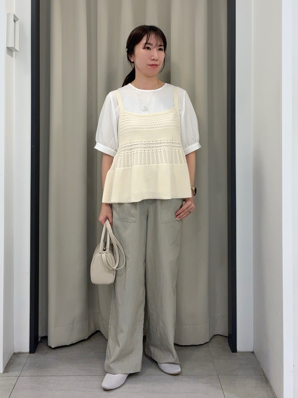 ホワイト系のその他トップス、ベージュ系のその他パンツ、ベージュ系のショルダーバッグを着用したレディースの春コーディネートの1枚目の写真