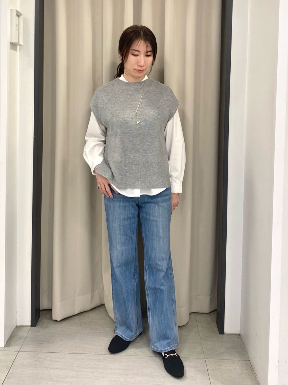グレー系のシャツ/ブラウス、ブルー系のデニムパンツ、ブラック系のショルダーバッグを着用したレディースの冬コーディネートの1枚目の写真