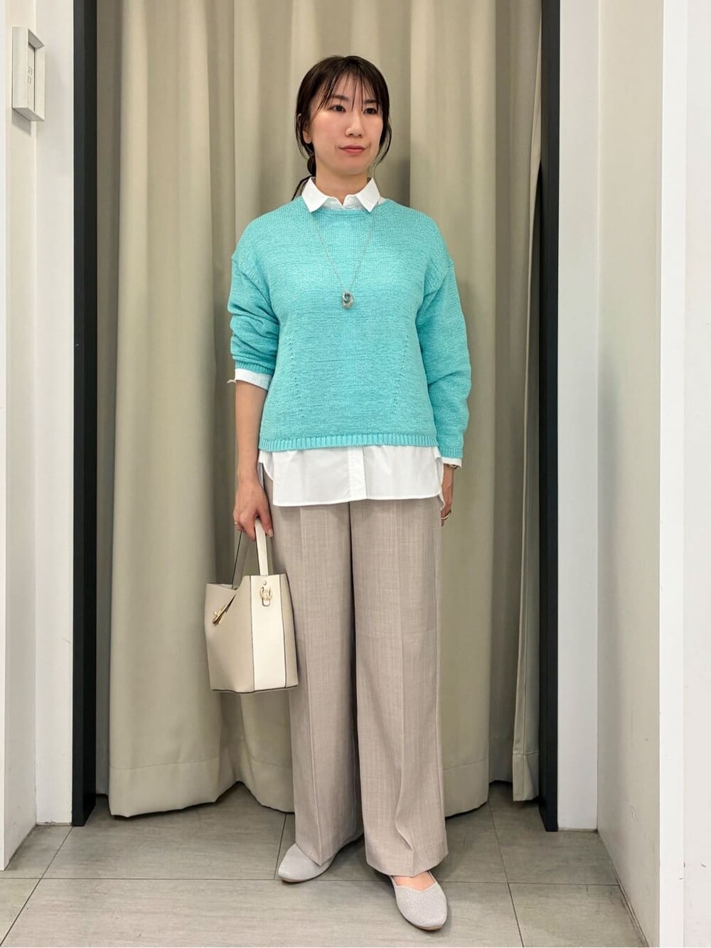 ブルー系のニット/セーター、ホワイト系のシャツ/ブラウス、ベージュ系のその他パンツを着用したレディースの春コーディネートの1枚目の写真