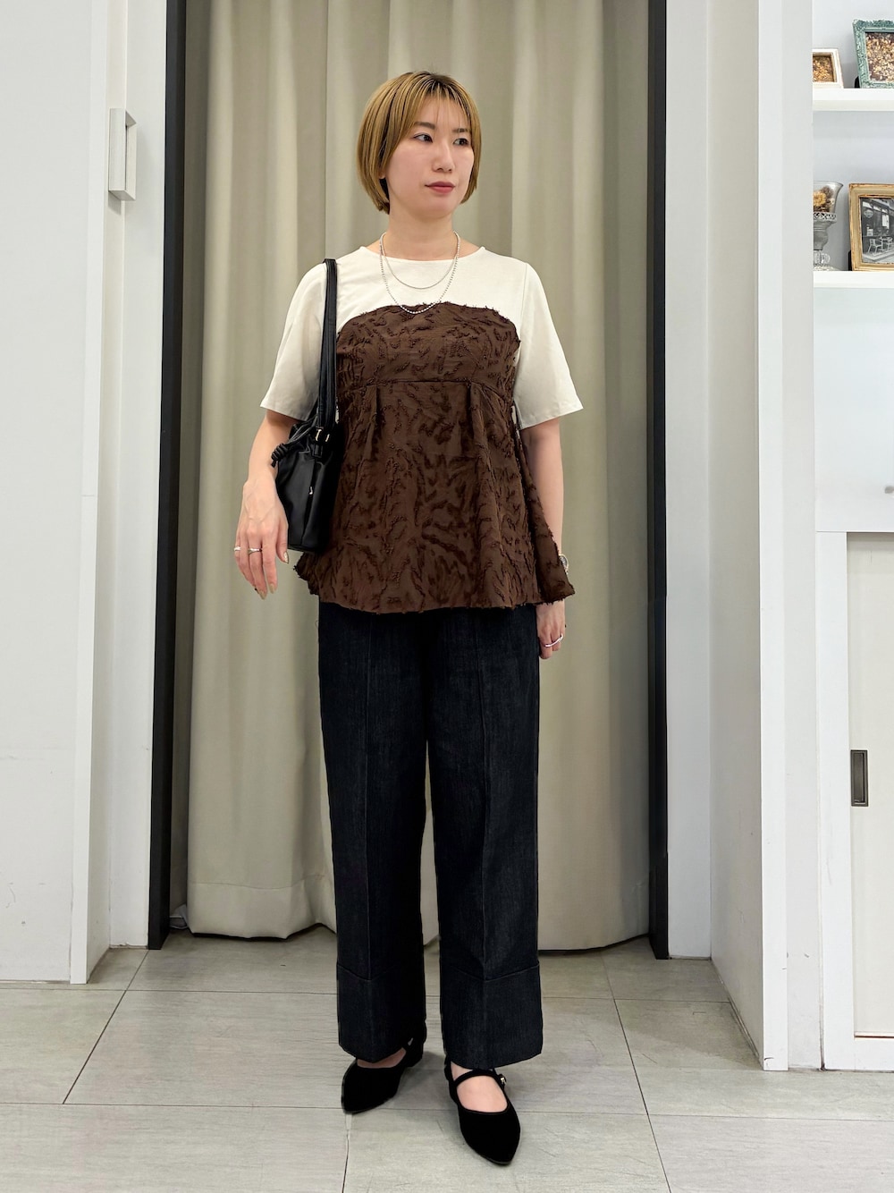 ブラウン系のTシャツ/カットソー、ブラック系のデニムパンツ、ブラック系のショルダーバッグを着用したレディースの秋コーディネートの1枚目の写真