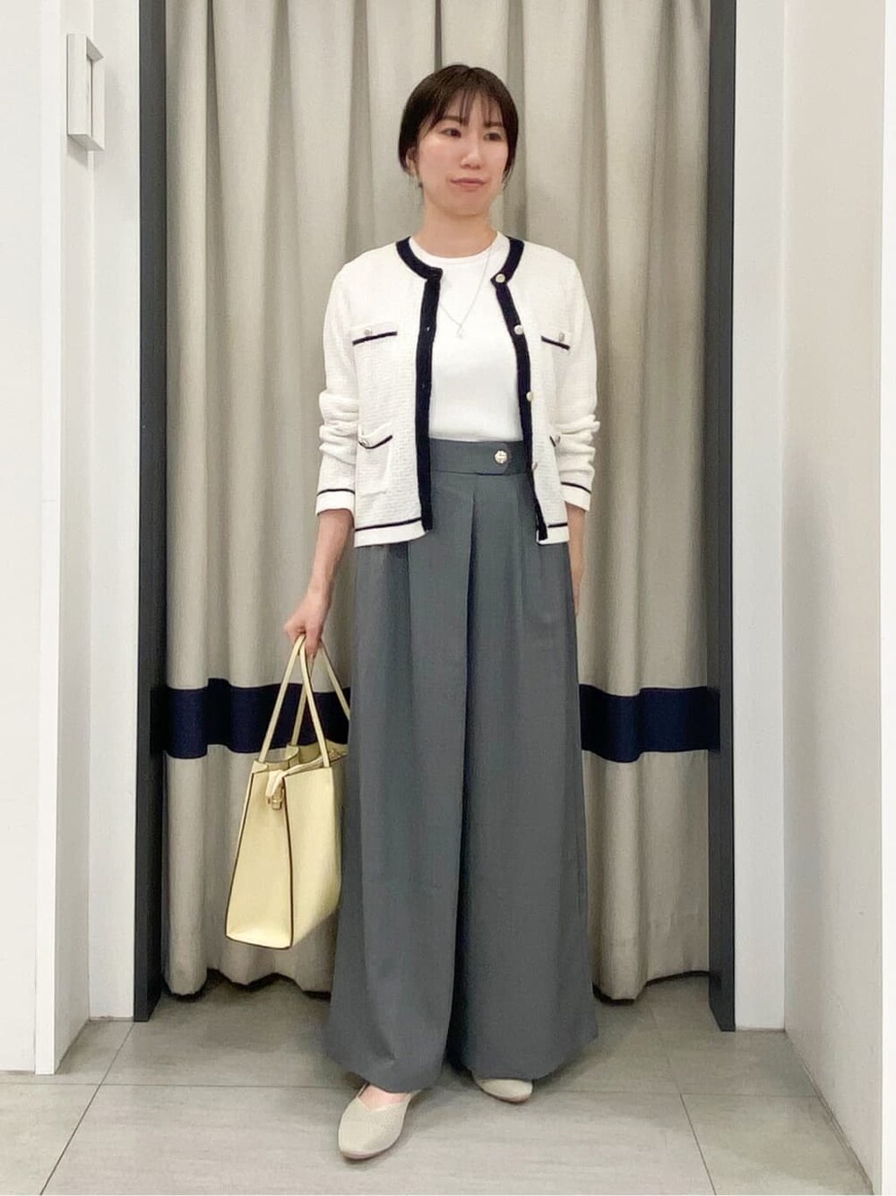 ホワイト系のカーディガン/ボレロ、ホワイト系のニット/セーター、グレー系のその他パンツを着用したレディースの春コーディネートの1枚目の写真