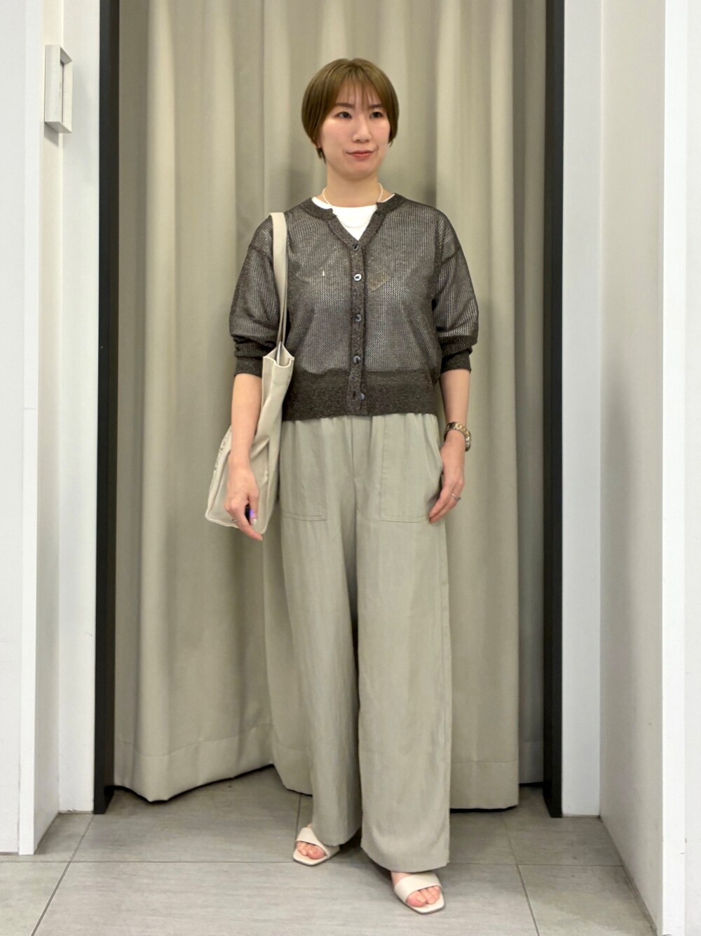 ブラウン系のカーディガン/ボレロ、ホワイト系のTシャツ/カットソー、ベージュ系のその他パンツを着用したレディースの春コーディネートの1枚目の写真