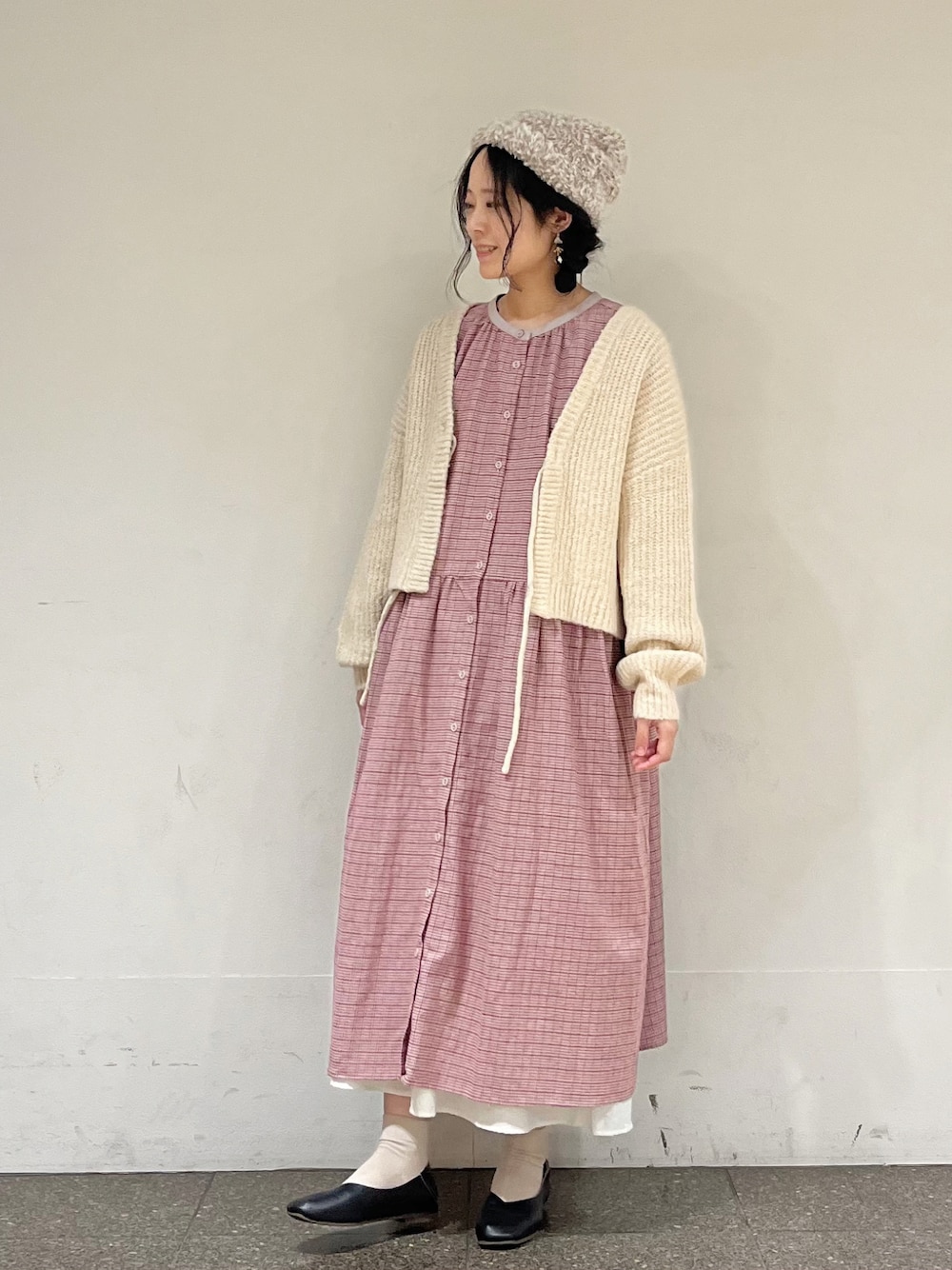 レッド系のワンピース、ホワイト系のカーディガン/ボレロ、ホワイト系のスカートを着用したレディースの冬コーディネートの1枚目の写真