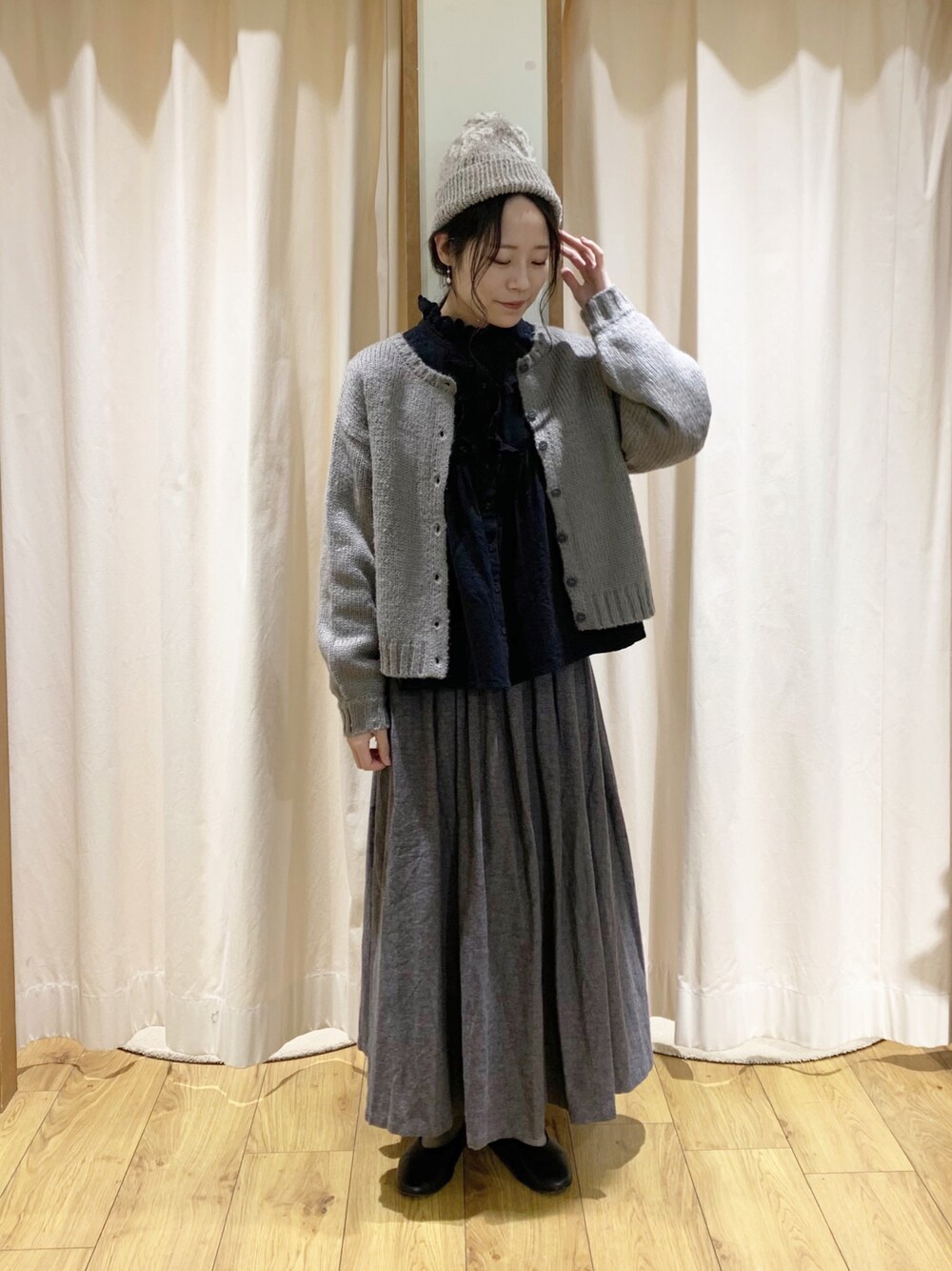 グレー系のカーディガン/ボレロ、ブラック系のシャツ/ブラウス、グレー系のスカートを着用したレディースの秋コーディネートの1枚目の写真