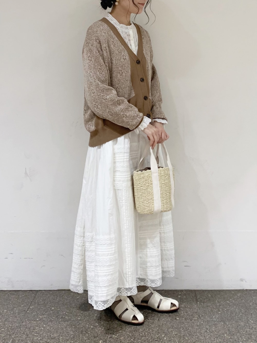 ベージュ系のカーディガン/ボレロ、ホワイト系のシャツ/ブラウス、ホワイト系のスカートを着用したレディースの春コーディネートの1枚目の写真
