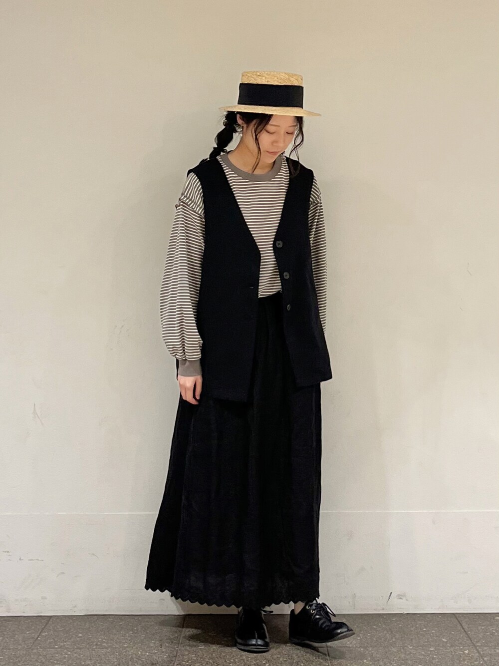 ブラウン系のTシャツ/カットソー、グレー系のベスト、ブラック系のスカートを着用したレディースの春コーディネートの1枚目の写真