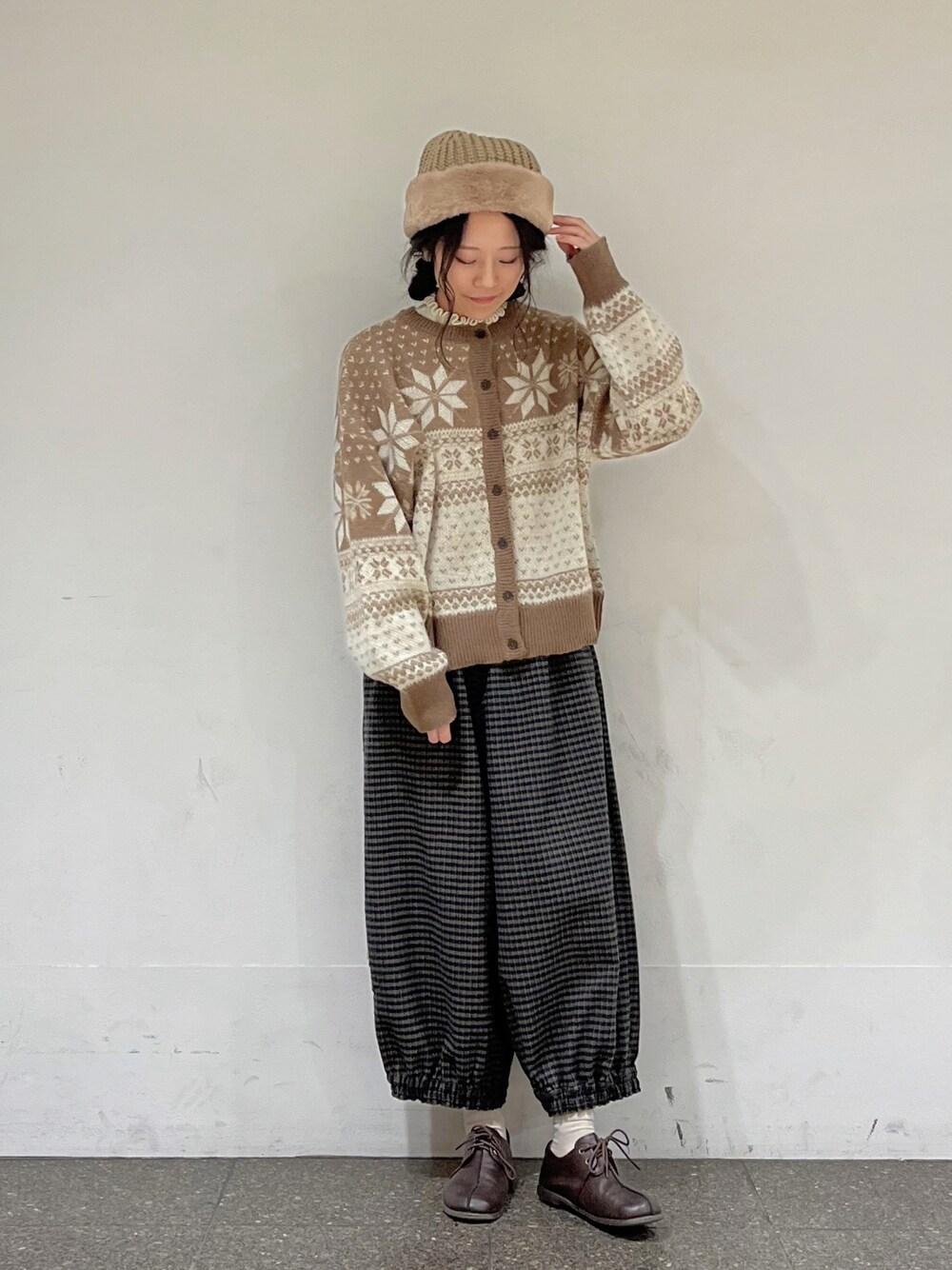 ブラウン系のカーディガン/ボレロ、ホワイト系のニット/セーター、ブラウン系のその他パンツを着用したレディースの冬コーディネートの1枚目の写真