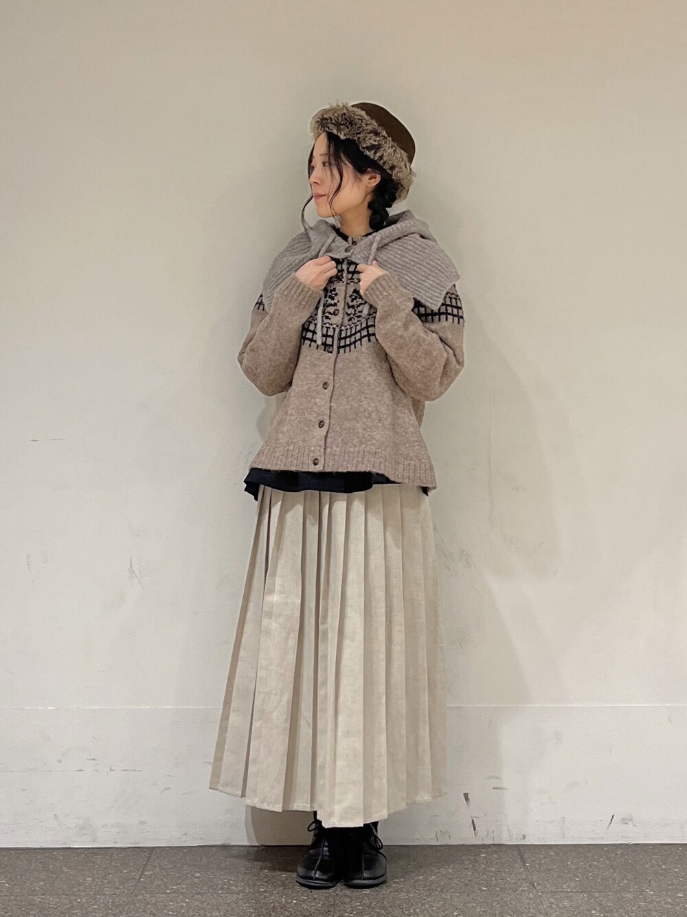 ブラウン系のカーディガン/ボレロ、ブラック系のシャツ/ブラウス、ベージュ系のスカートを着用したレディースの冬コーディネートの1枚目の写真