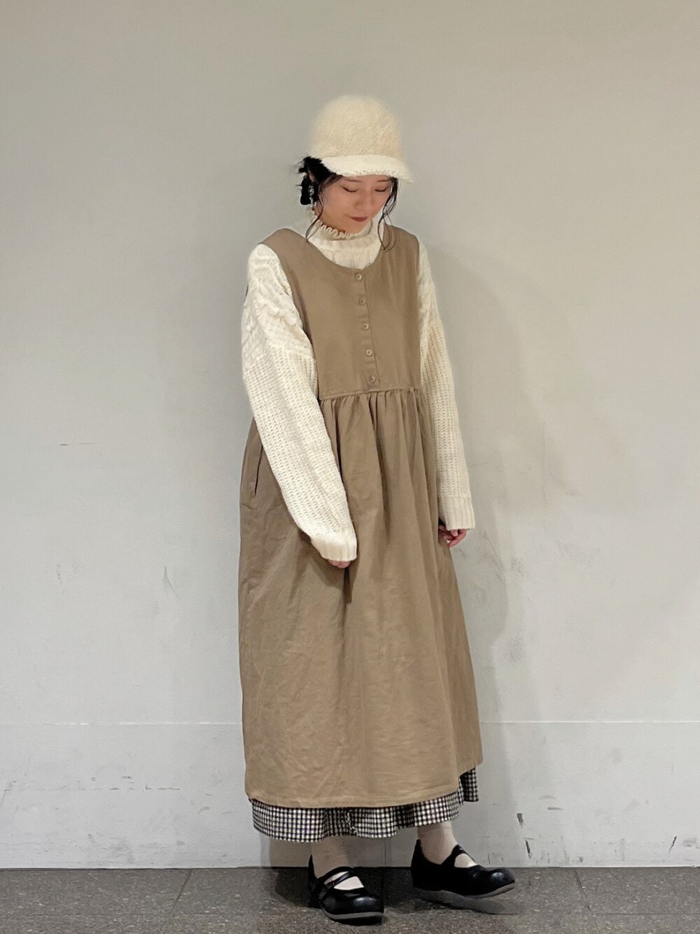 ホワイト系のカーディガン/ボレロ、ホワイト系のニット/セーター、ベージュ系のワンピースを着用したレディースの冬コーディネートの1枚目の写真