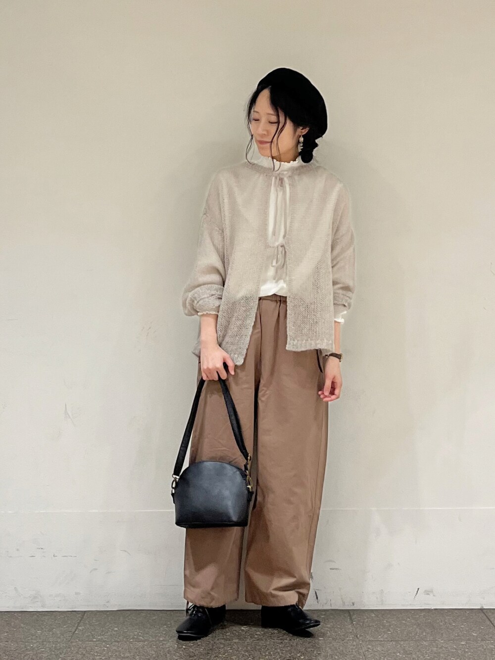 ブラウン系のその他パンツ、ブラック系のハンドバッグ、グレー系のカーディガン/ボレロを着用したレディースの冬コーディネートの1枚目の写真