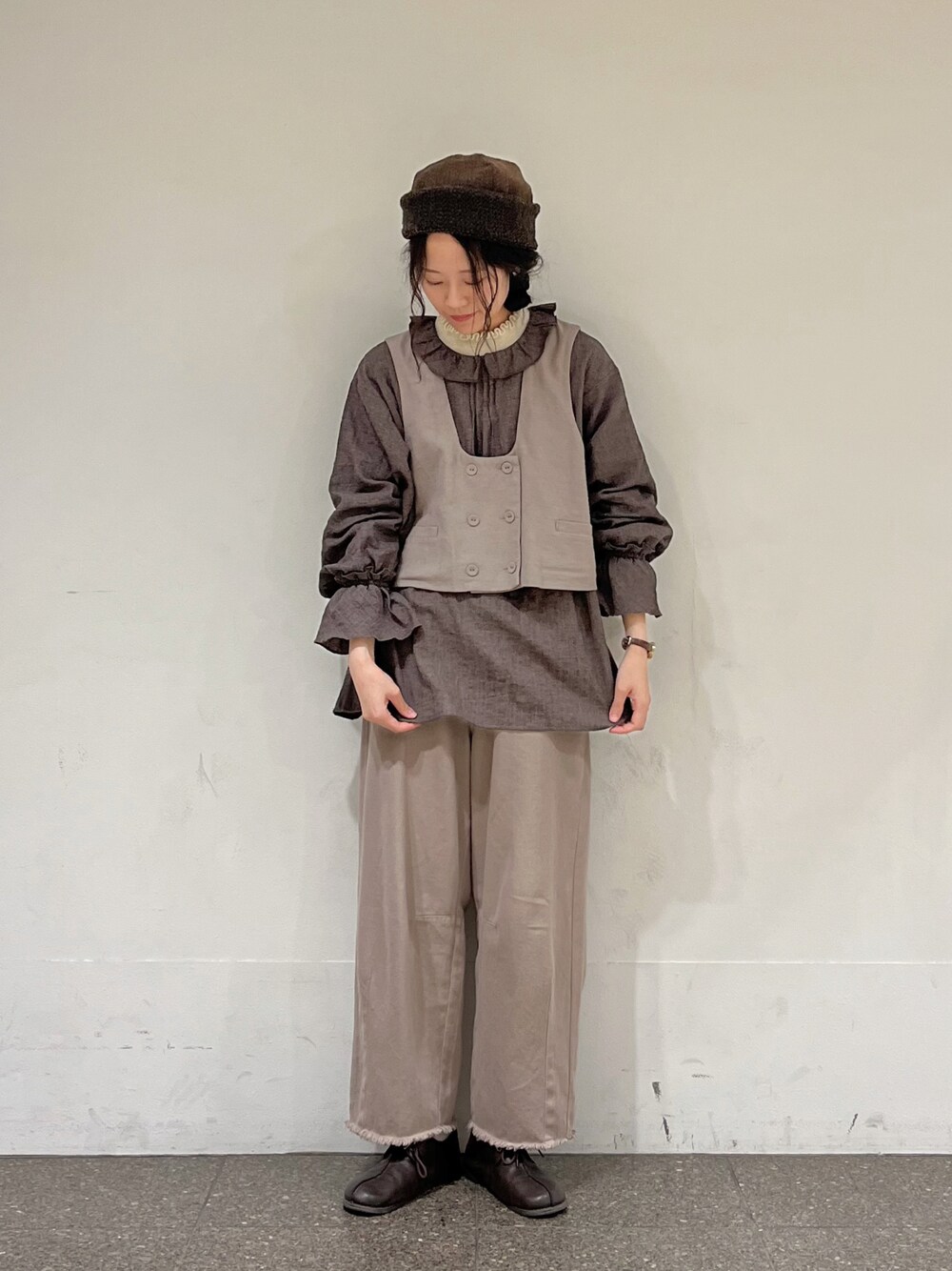 ブラウン系のシャツ/ブラウス、ブラウン系のベスト、ホワイト系のニット/セーターを着用したレディースの冬コーディネートの1枚目の写真